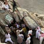 ...в то время как верующие собираются у входа в пещеру Хира недалеко от вершины горы.